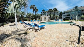 A pool area with lounge chairs, a small pool, and a building in the background. - Lovely 1BR condo in Myrtlewood (Myrtle Beach)