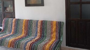 A room with a bench, a framed picture on the wall, and wooden doors. - Bienvenidos a Casa Violeta (Atalbéitar)