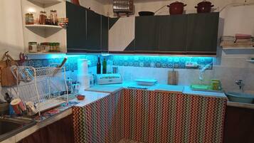 Refrigerador, cafetera y tetera, utensilios de cocina y condimentos