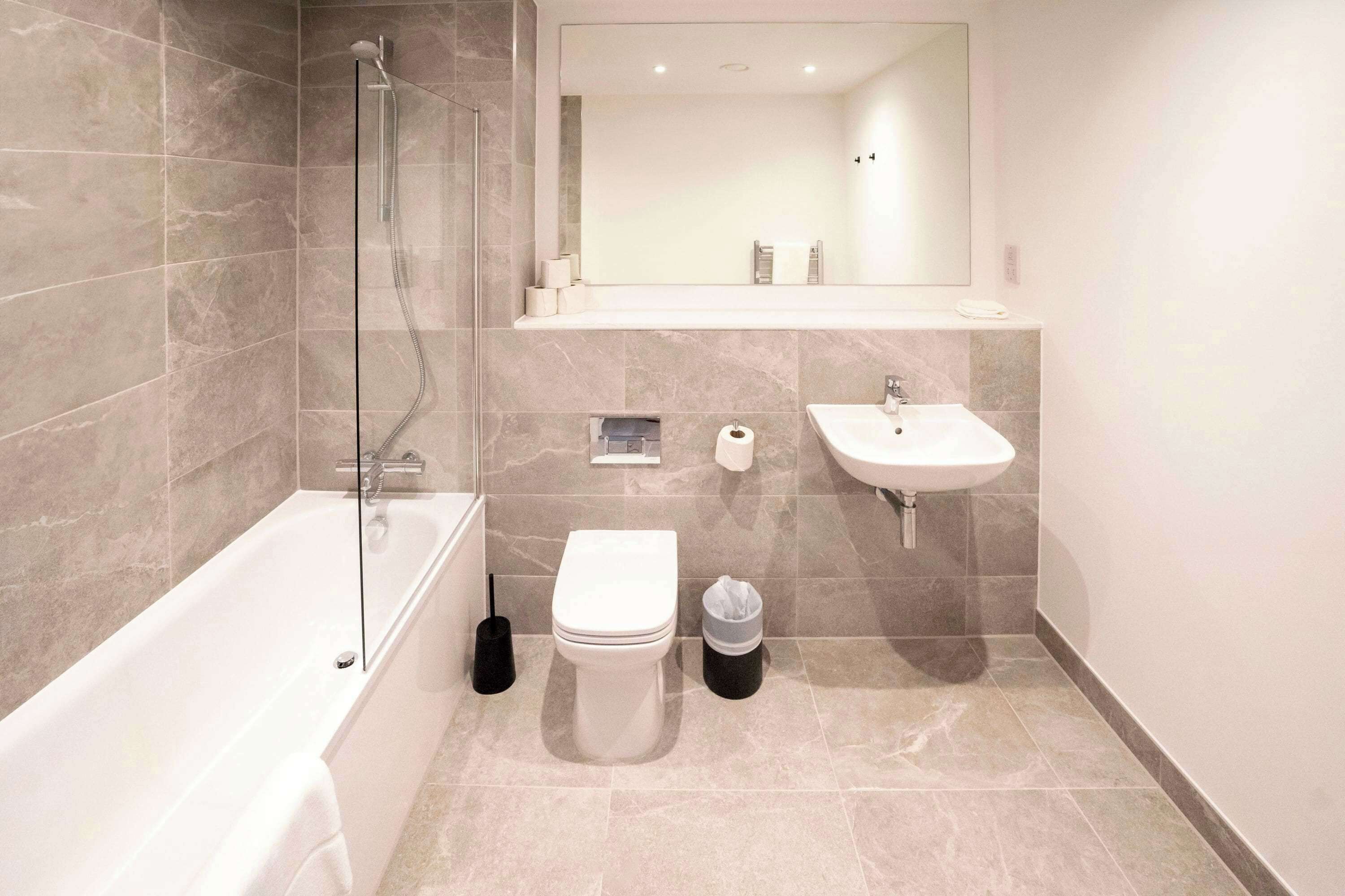 Un baño moderno con bañera, inodoro, lavabo y ducha.