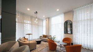 A modern living room with a sofa, armchairs, a coffee table, and a floor lamp. - Organika Suite & 2BR Luxury w/ Skyline Views & Gym Access! (Greater Manchester)