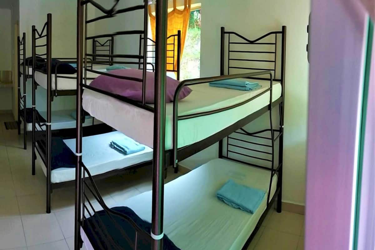 Un dormitorio con literas, un equipo de aire acondicionado y una ventana con cortinas.