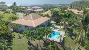 A large house with a swimming pool surrounded by lush greenery and palm trees. - LA VILLA LES 4 COLIBRIS, 3 ch, piscine avec une vue imprenable sur la montagne  (LE VAUCLIN)