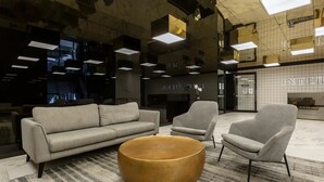 A modern lobby with a sofa, two armchairs, and a round coffee table. - Huge private wrap-around terrace near Crown Casino (Southbank)