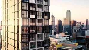 A modern high-rise building with multiple balconies and a cityscape view in the background. - Huge private wrap-around terrace near Crown Casino (Southbank)
