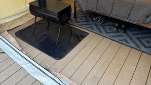 Ein Zelt mit einem Bett, einem Tisch und einem tragbaren Heizgerät.