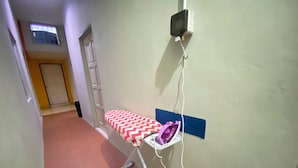 A hallway with a wall-mounted ironing board and an iron. - Hotel O D Qamar Motel (Langkawi)