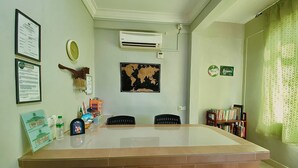 A reception desk with a world map, framed certificates, and a small bookshelf. - Hotel O D Qamar Motel (Langkawi)