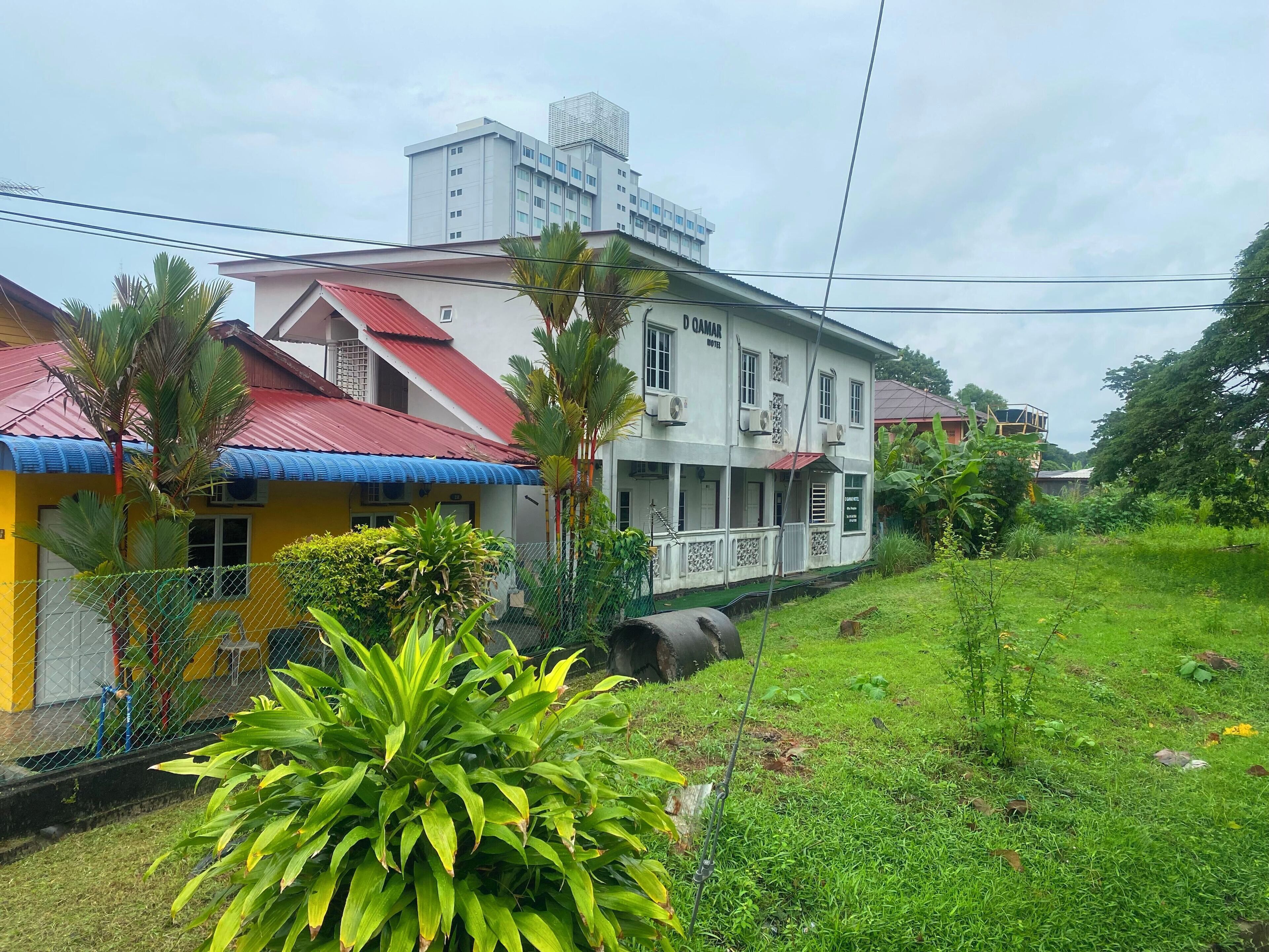A hotel with a white facade, red roof, and a sign that reads "D OAMAR HOTELS".