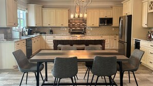 A spacious kitchen with a large island, dark wood cabinets, and a modern chandelier. - Peaceful Lake Wylie Waterfront Home in Belmont. Great Views, Beautiful interiors (Belmont)