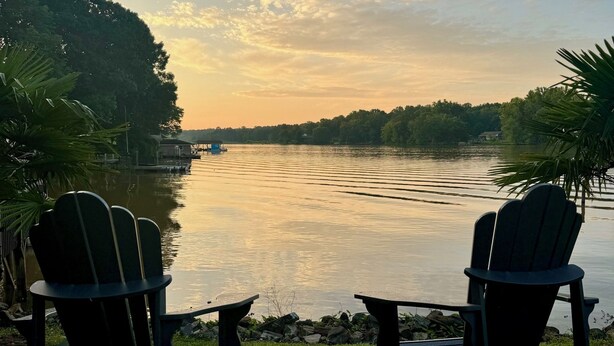 Two Adirondack chairs facing a calm lake with a sunset in the background. - Peaceful Lake Wylie Waterfront Home in Belmont. Great Views, Beautiful interiors (Belmont)