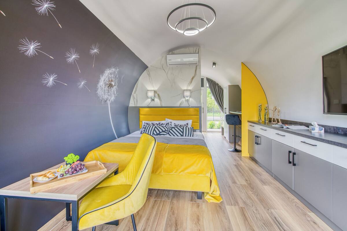A modern bedroom with a bed, bedside table, and a chair.
