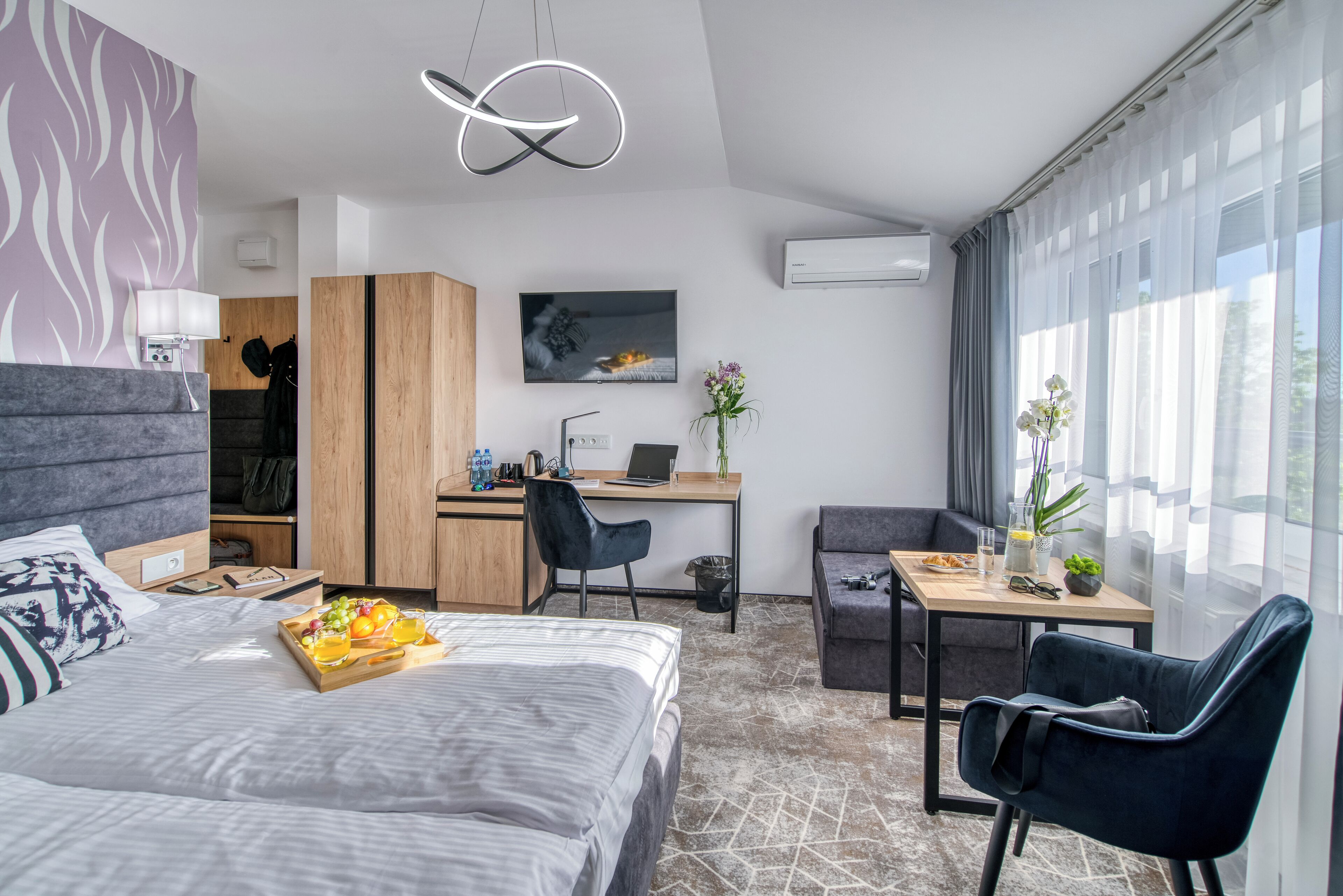 Una habitación de hotel moderna con cama, escritorio y zona de estar.
