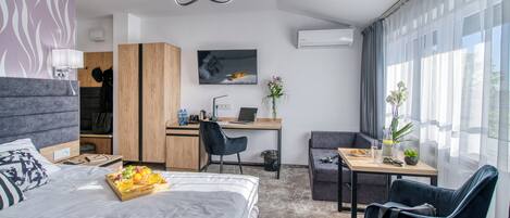Una habitación de hotel moderna con cama, escritorio y zona de estar.