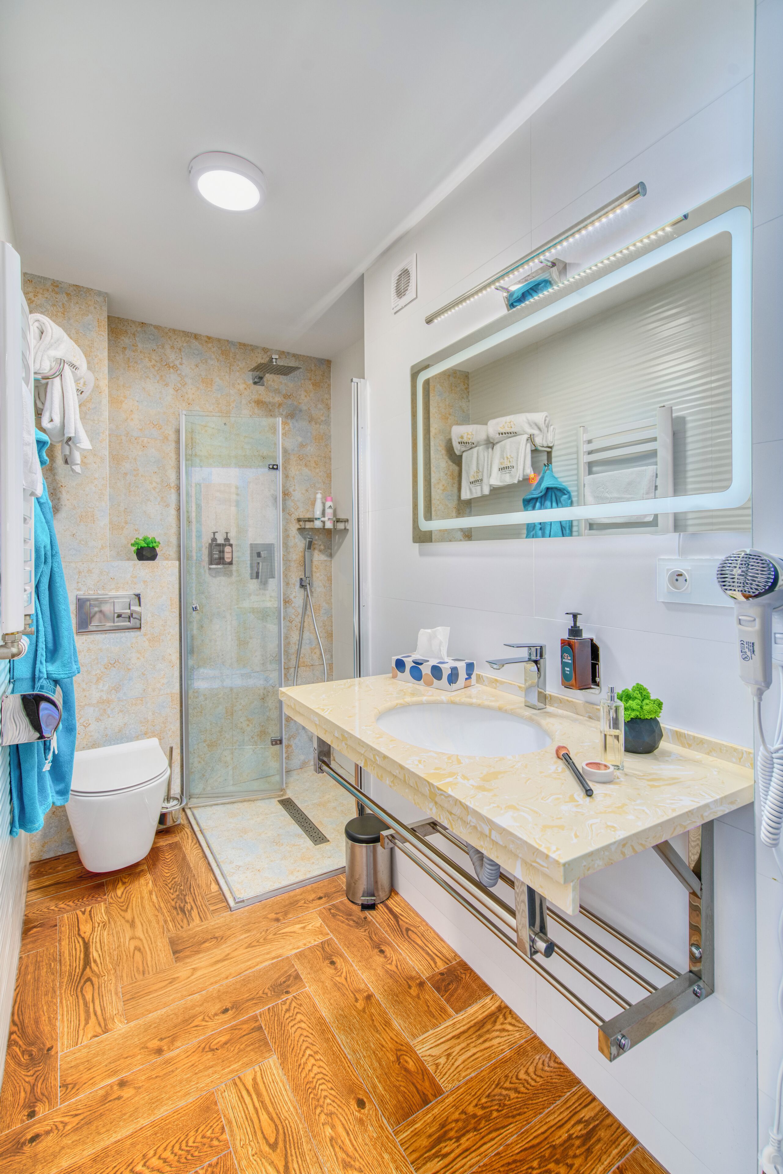 Une salle de bain moderne dotée d’une douche à parois de verre, d’un meuble-lavabo à deux vasques et d’un grand miroir.