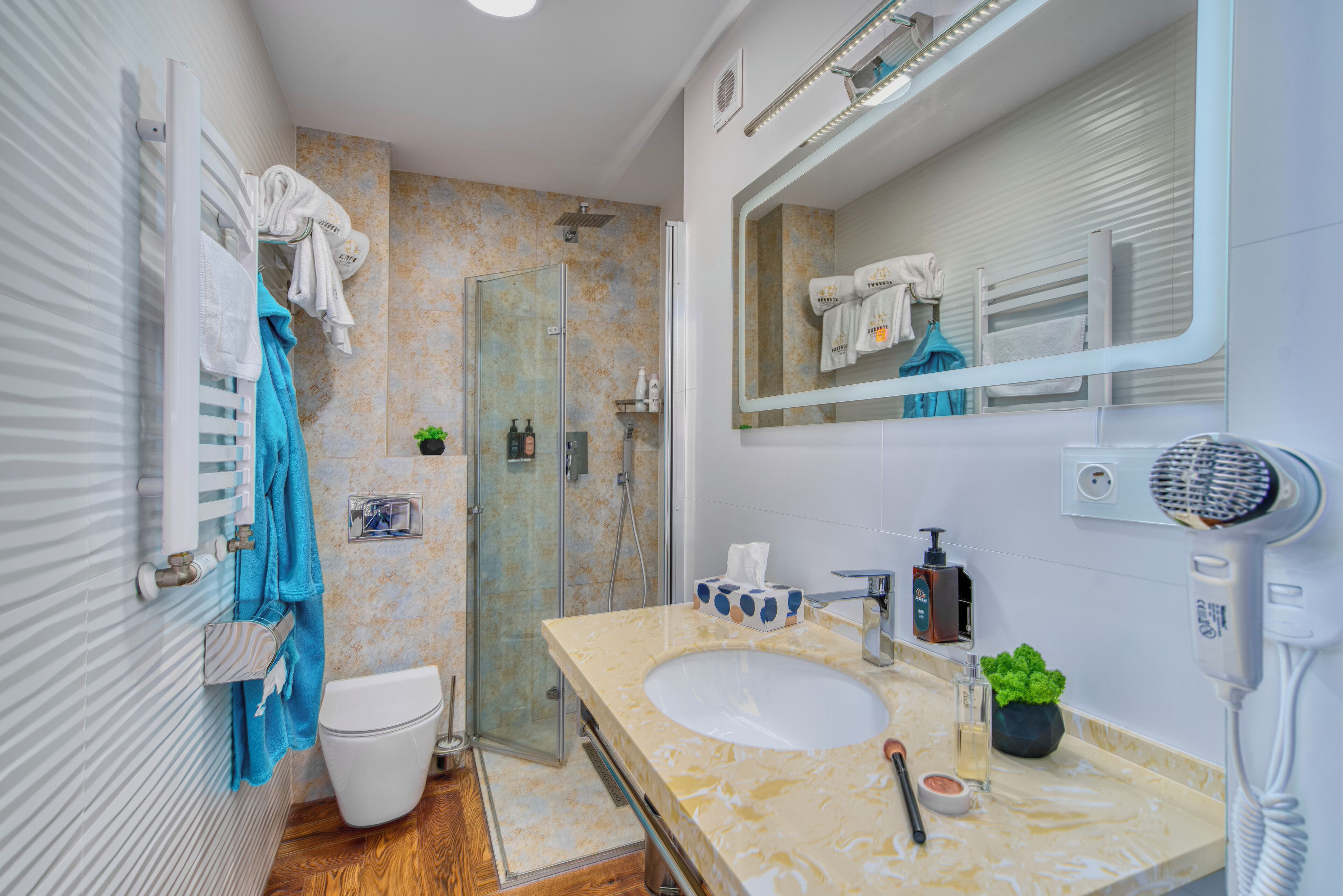 Een moderne badkamer met douche, toilet en wastafel.
