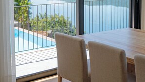 A balcony with a view of a lake and hills, a wooden table, and four chairs. - Lajinha do Ave (Braga)