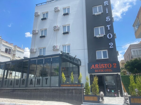 Un edificio moderno con un cartello che indica 'ARISTO 2 BUTIK HOTEL'.