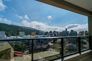 Een balkon met uitzicht op een stadsbeeld, inclusief gebouwen en een heuvel op de achtergrond.