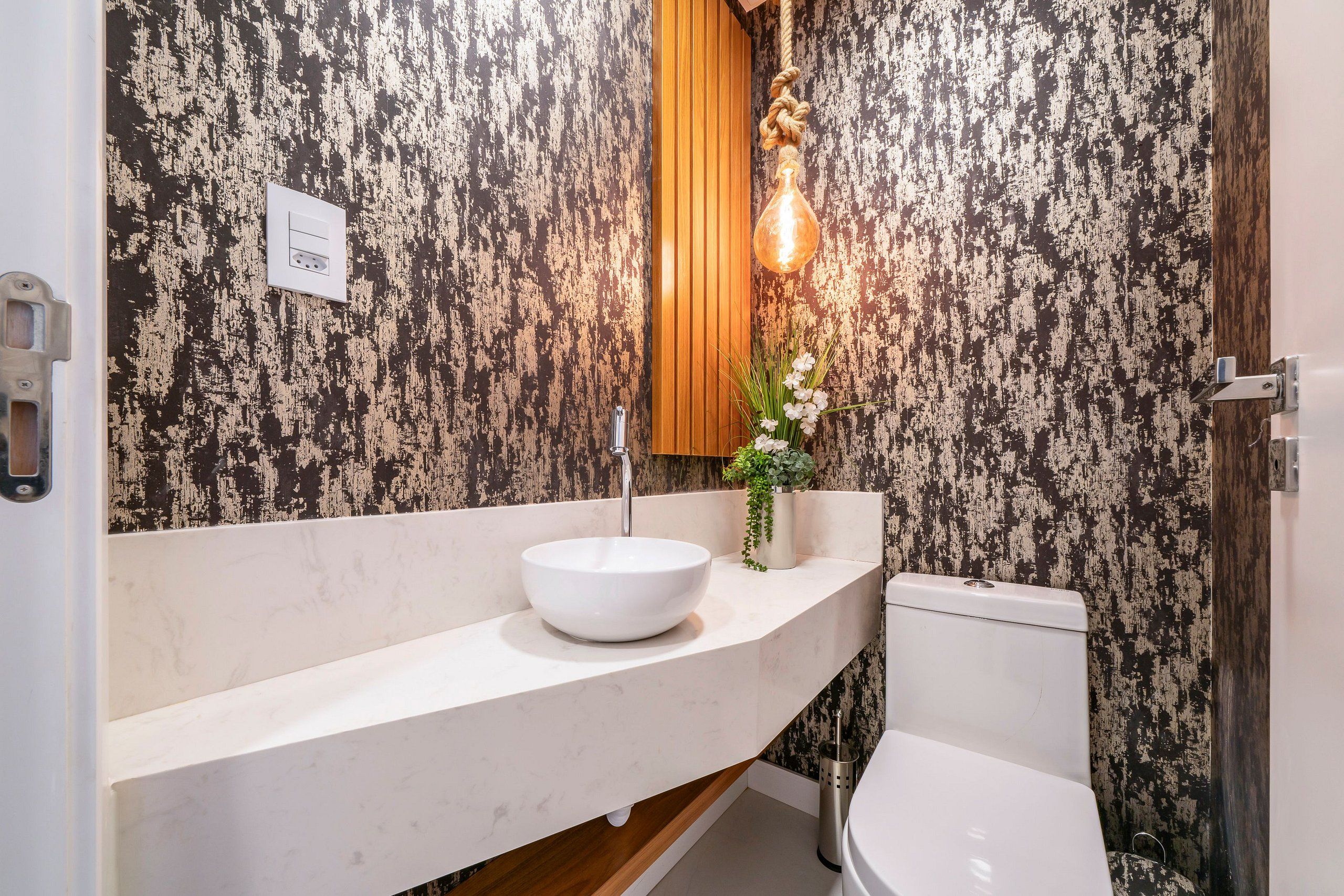 A bathroom with a white sink, wooden vanity, and a toilet.