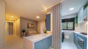 Una cocina moderna con armarios azules, encimera blanca y horno empotrado.