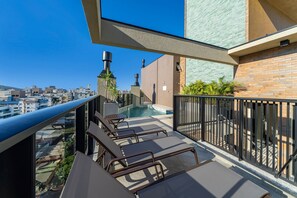 A rooftop terrace with a pool, lounge chairs, and a view of the cityscape. - Las Vegas  (Bombinhas)