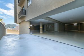 Un vaste espace intérieur doté d’un plancher plat, de grandes colonnes et offrant une vue sur des bâtiments et des collines en arrière-plan.