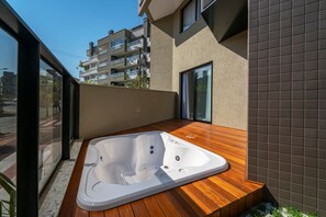 A modern outdoor hot tub on a wooden deck with a city view. - Las Vegas  (Bombinhas)