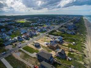 Vista aérea de una zona residencial costera con casas, calles y una playa.