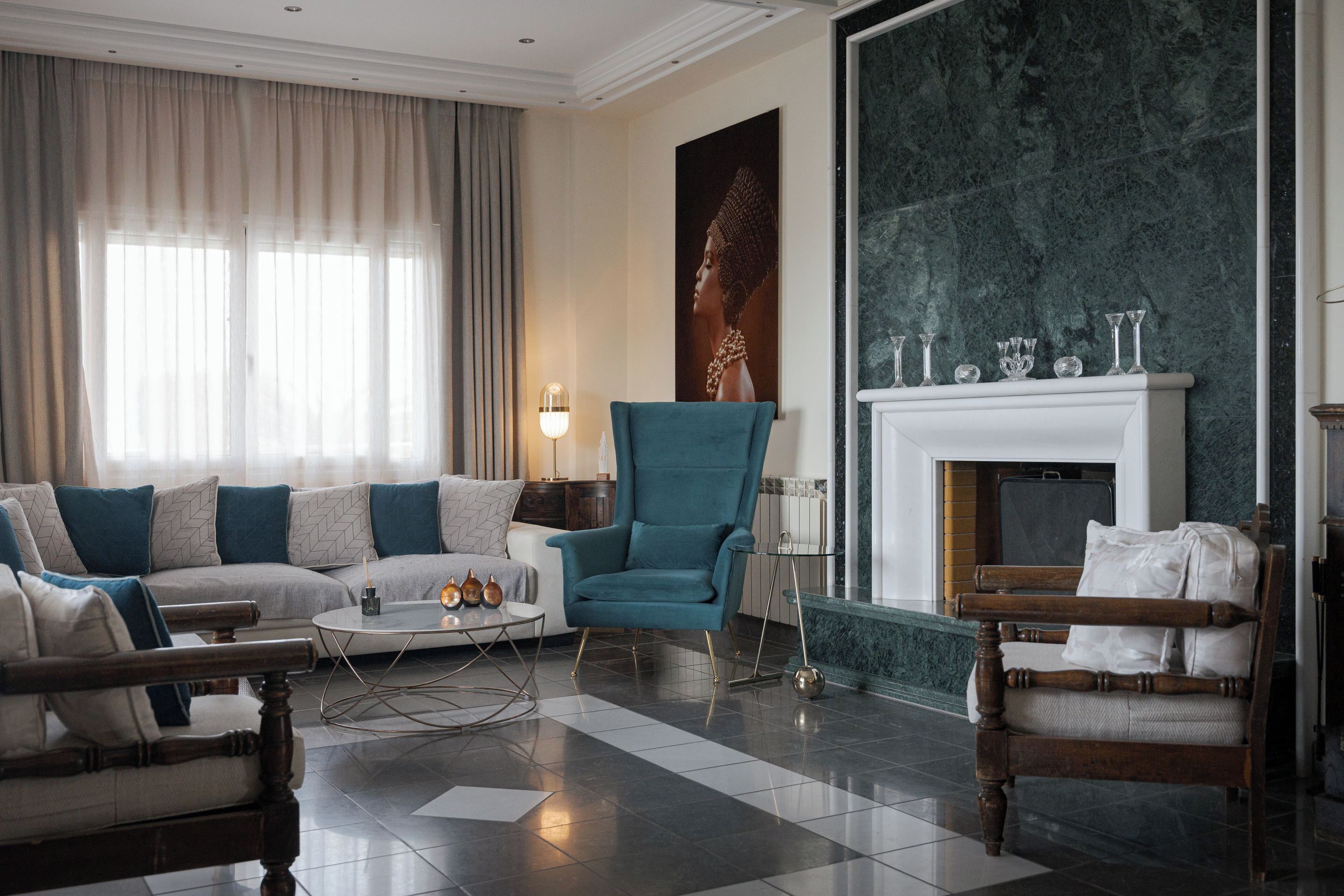 Una sala de estar moderna con un sofá, sillones, una mesa de centro y una chimenea.