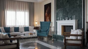 Una sala de estar moderna con un sofá, sillones, una mesa de centro y una chimenea.