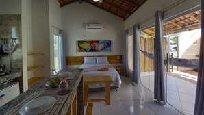 Une chambre à coucher avec un lit, une table de chevet, une fenêtre et un ventilateur de plafond.