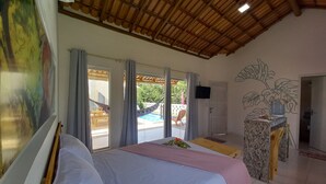 Une chambre dotée d’un lit, d’une télévision, d’un distributeur d’eau et offrant une vue sur une piscine et un jardin.