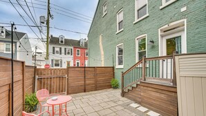 A patio with a wooden fence, a small table, and two chairs. - Chic Lancaster Vacation Rental, Walkable Location! (Lancaster)