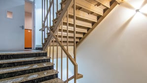 Una escalera con barandillas de madera y escalones de granito que conduce a un piso superior.