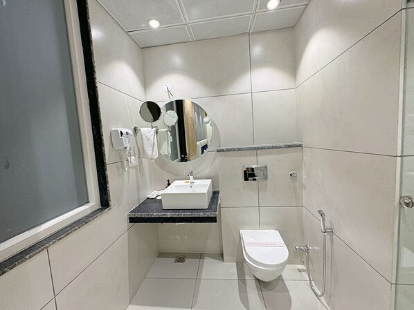 Une petite salle de bain moderne, équipée de toilettes, d’un lavabo et d’un miroir.