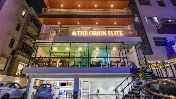 Un hotel de varios pisos con un letrero llamativo que dice "THE ORION ELITE".