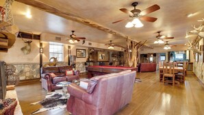A spacious living room with a pool table, leather sofas, and wooden flooring. - Rural Texas Villa w/ Hot Tub - Horses Welcome! (Tarpley)