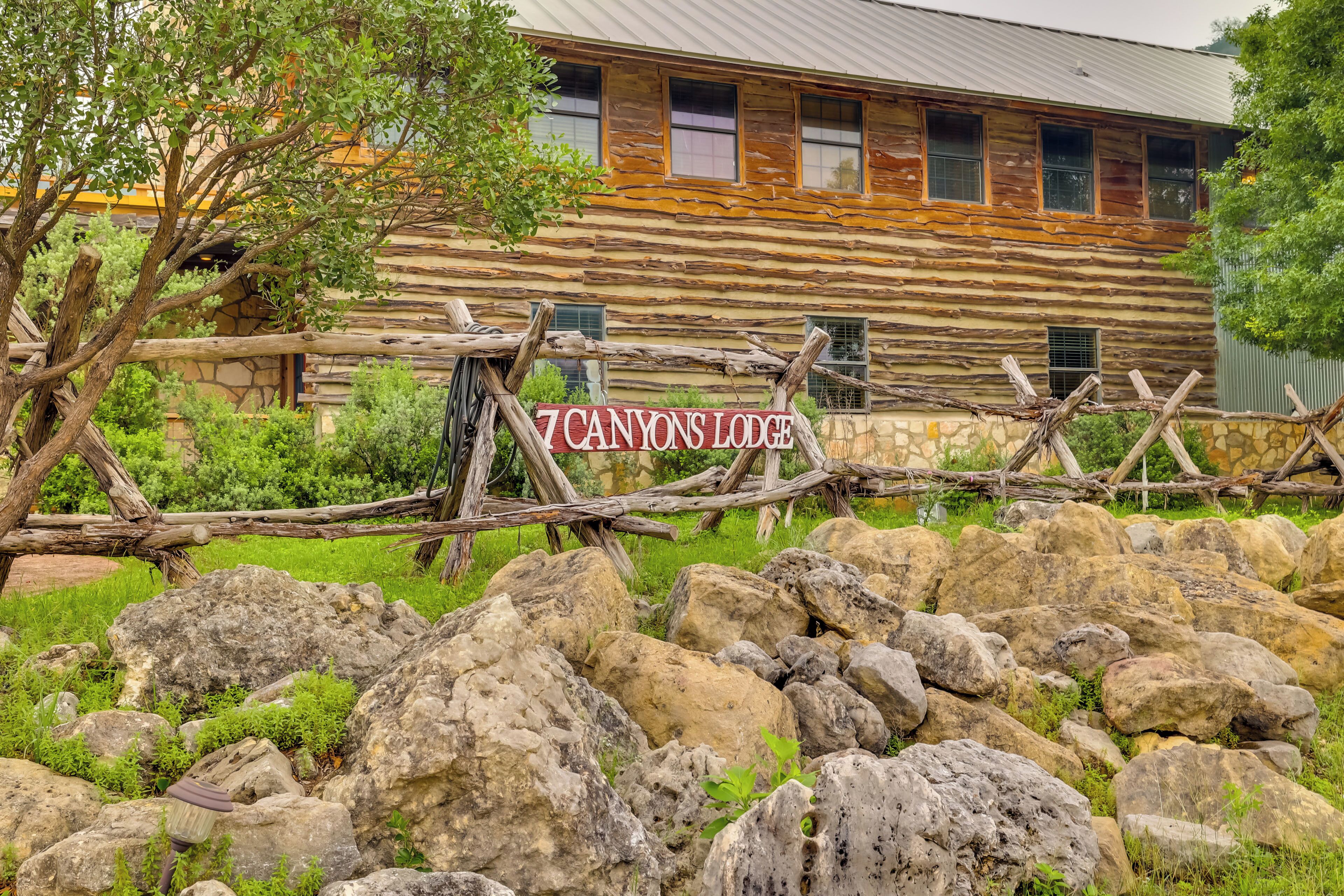 A rustic log cabin with a sign reading "7 CANYONS Lodge".