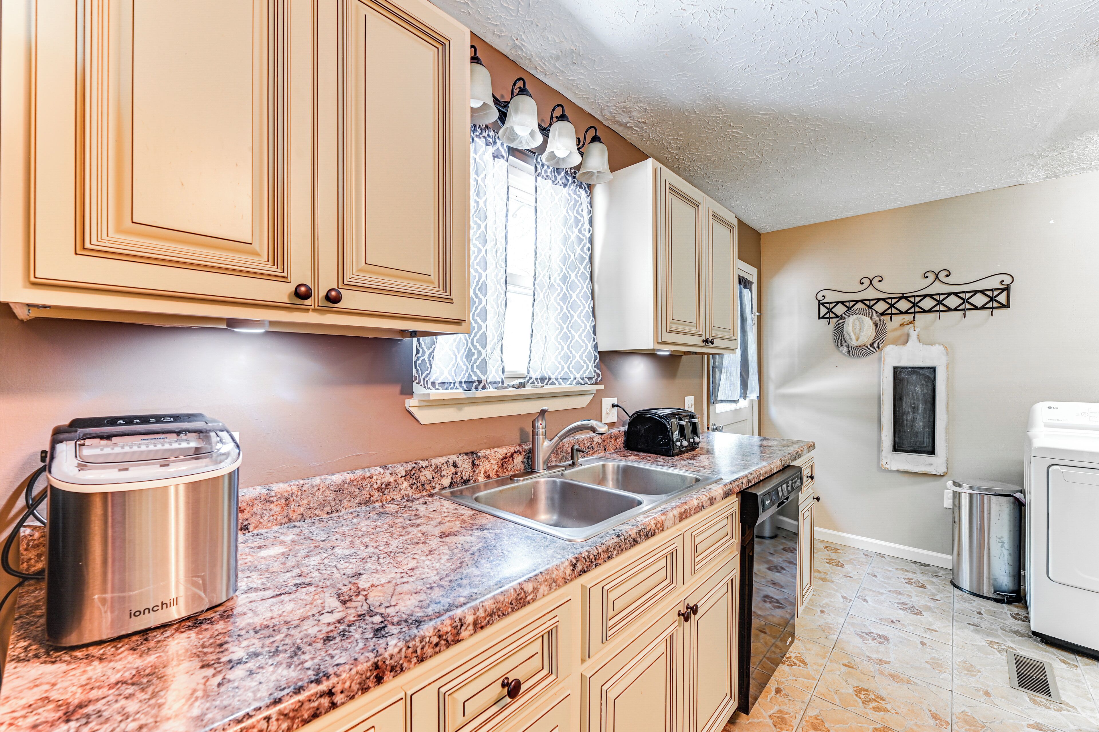 A kitchen with granite countertops, stainless steel appliances, and beige cabinetry.