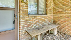 A brick wall with a wooden bench and a window with blinds. - Cozy Meyers Lake Townhome: Near Hall of Fame! (Canton)