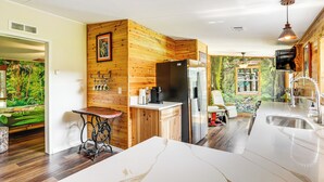 A modern kitchen with wooden accents, a marble countertop, and a built-in refrigerator. - Sleep With Sloths & Lemurs! Modern Webster Home (Webster)