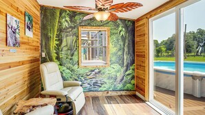 A room with a wooden interior, a ceiling fan, a large window, and a view of an outdoor swimming pool. - Sleep With Sloths & Lemurs! Modern Webster Home (Webster)