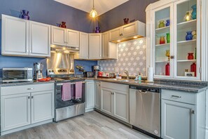 A modern kitchen with white cabinets, stainless steel appliances, and a patterned backsplash. - Pet-friendly Indianapolis Home Near Mile Square! (Indianapolis)