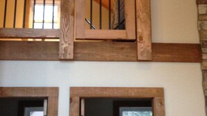 Un escalier en bois avec une rampe en métal menant à une mezzanine.
