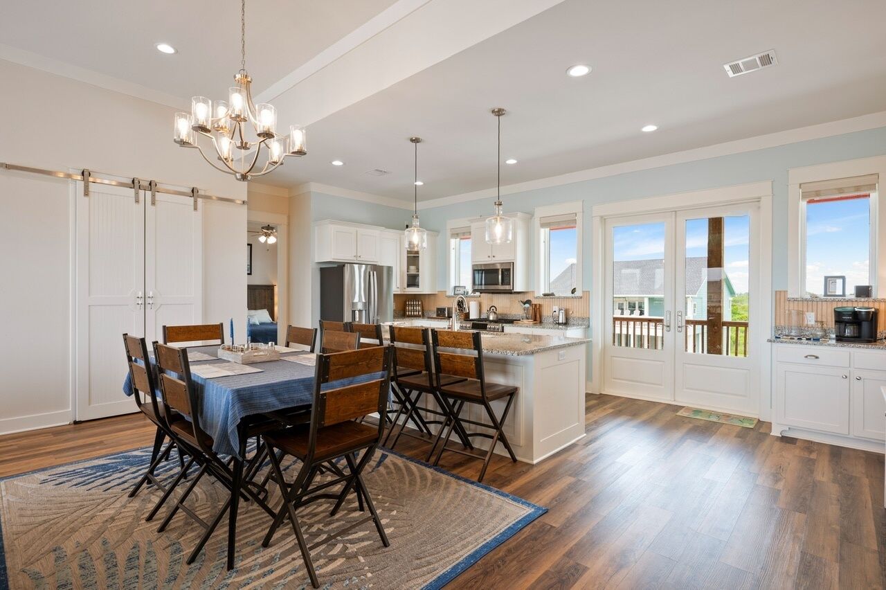 A spacious kitchen with a central island, modern appliances, and a dining area with a chandelier.
