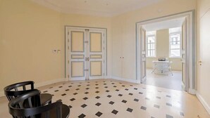 A room with a checkered floor, a double door, and a small table with chairs. - PONT NEUF - A TESTAMENT TO PARISIAN SOPHISTICATION OF 200 M2 – 3 BEDOROOM (Paris)