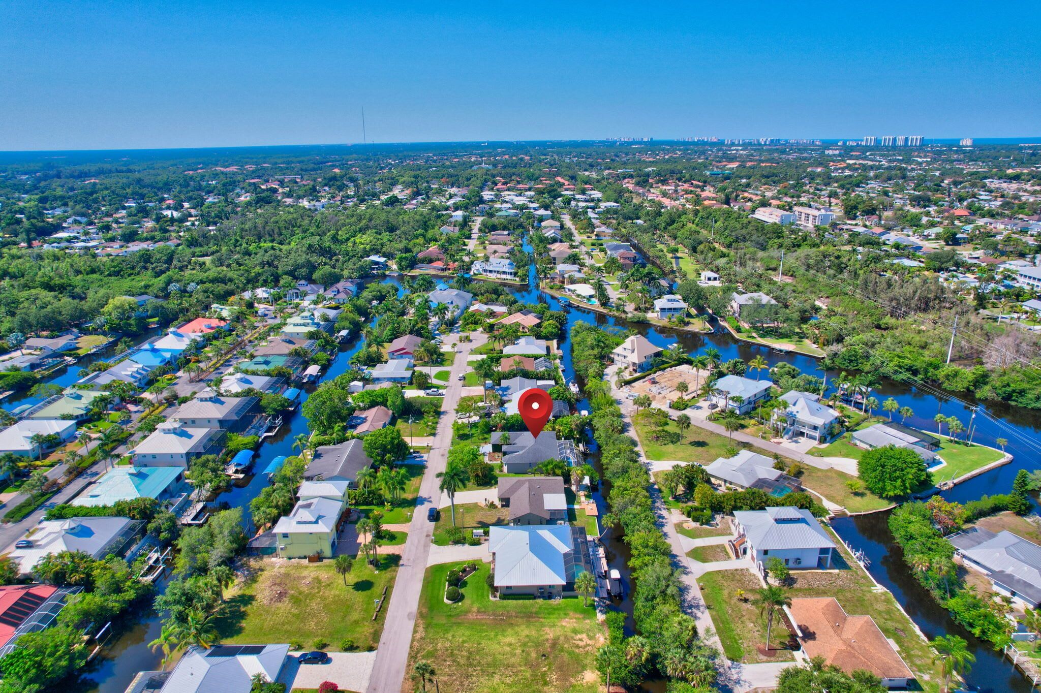 Luchtbeeld van een woongebied met huizen, een rivier en een rode markering.