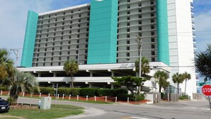 A large hotel with a prominent 'Royal Garden' sign, multiple floors, and a parking garage. - Royal Garden Unit 609 -  2 Bedroom, 2 Bath Oceanfront Condo (Garden City Beach)