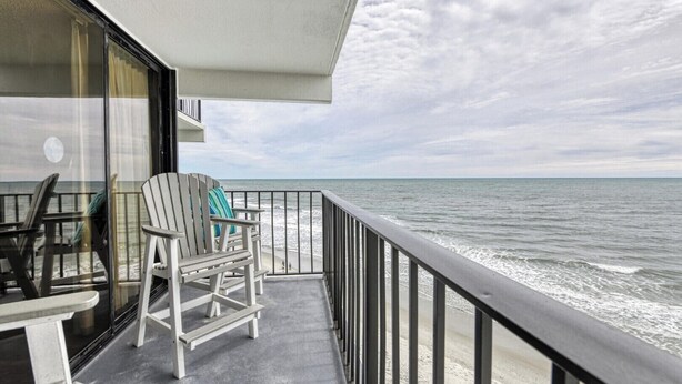 A balcony with a view of the ocean, a chair, and a table. - Royal Garden Unit 609 -  2 Bedroom, 2 Bath Oceanfront Condo (Garden City Beach)